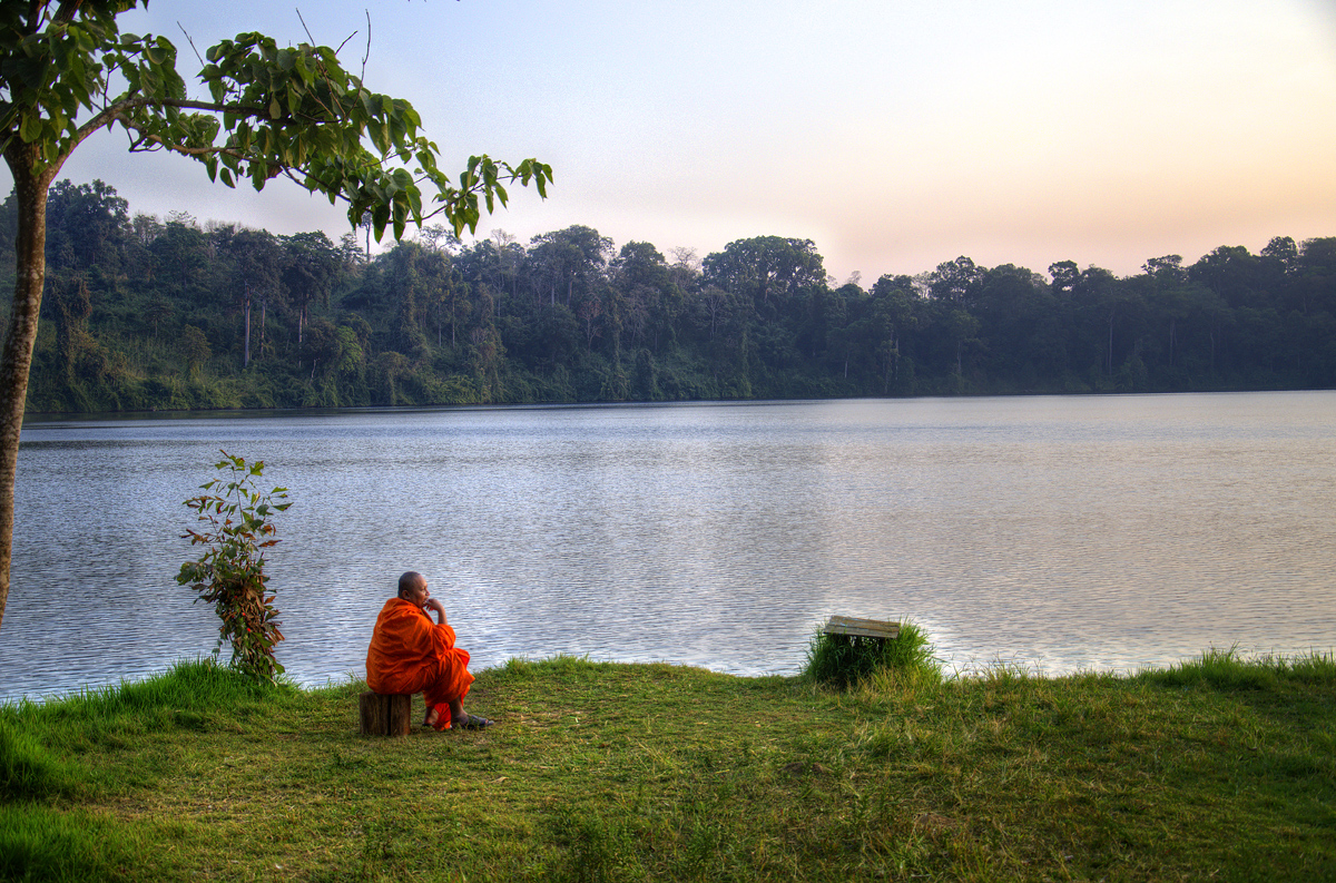 A buddhist monk, meditating and basking in the serenity at Yeak Loum Lake in Ratanakiri Province, Cambodia.