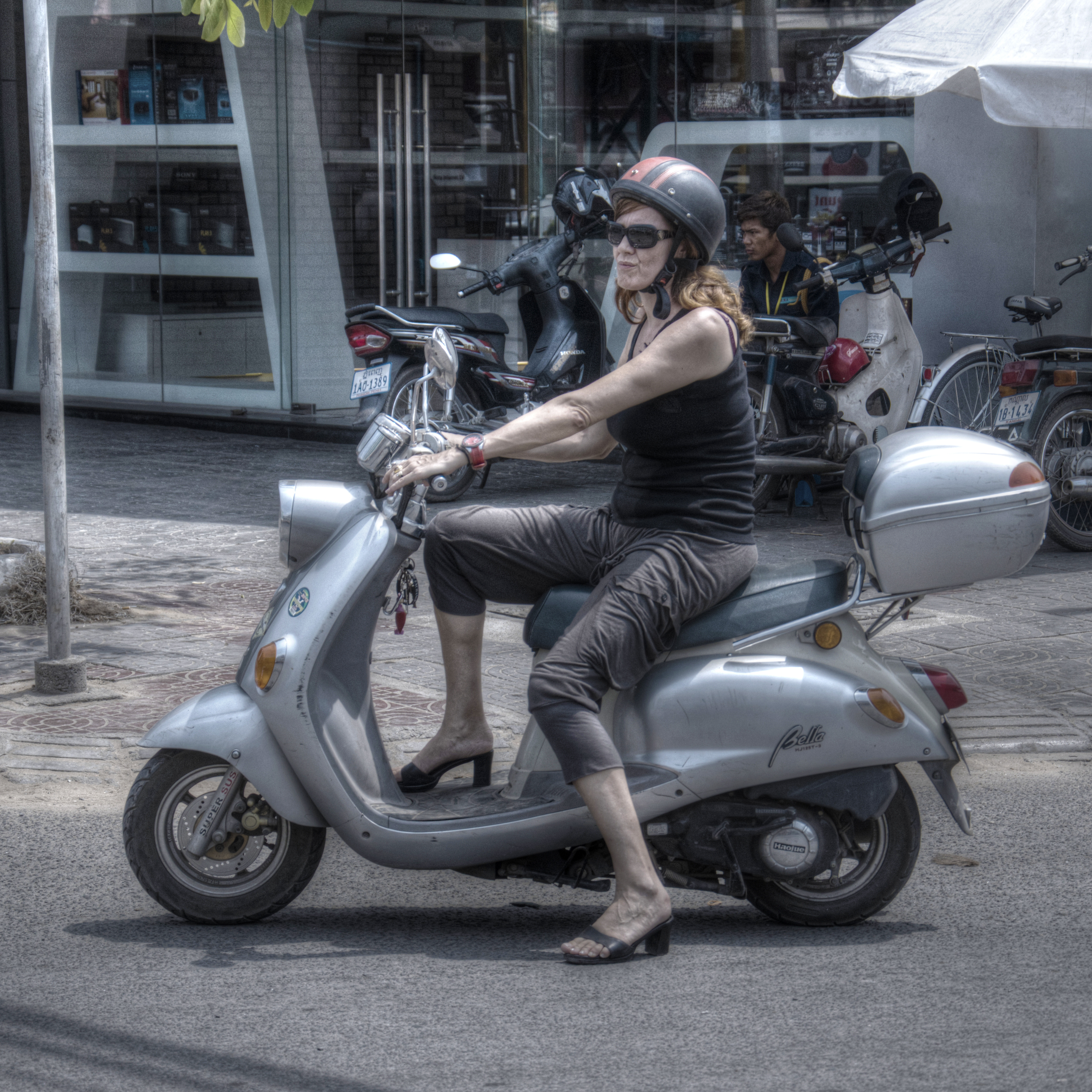 An expat in Phnom Penh, Cambodia, riding a German Zundapp Bella scooter.
